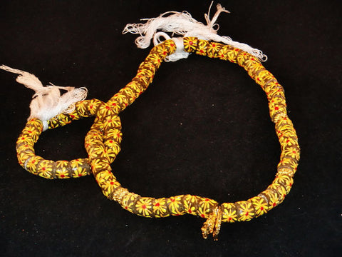 Brown with hand-painted multi-colored starburst pattern & golden accents; on string / tie-on; neck beads approx. 25" long; wrist beads approx. 10 1/2" long.